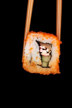 Delicious sushi and chopsticks on black background clipart