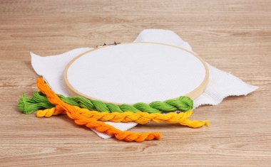 The embroidery hoop with canvas and bright sewing threads for embroidery in clipart