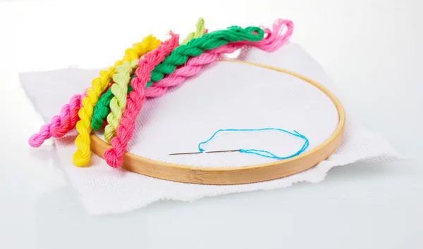 The embroidery hoop with canvas and bright sewing threads for embroidery is — Stock Photo, Image