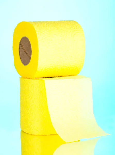 Dois rolos amarelos de papel higiênico sobre fundo azul — Fotografia de Stock