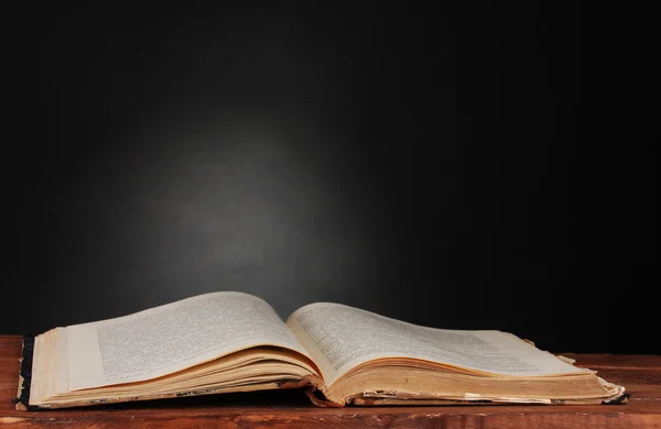 Старая книга на деревянном столе на сером фоне — стоковое фото