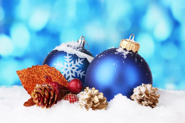 Beautiful blue Christmas balls and branch on snow on blue background — Stock Photo, Image