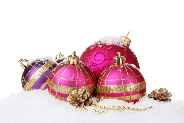 Hermoso rosa bolas de Navidad y conos en la nieve aislado en blanco —  Fotos de Stock