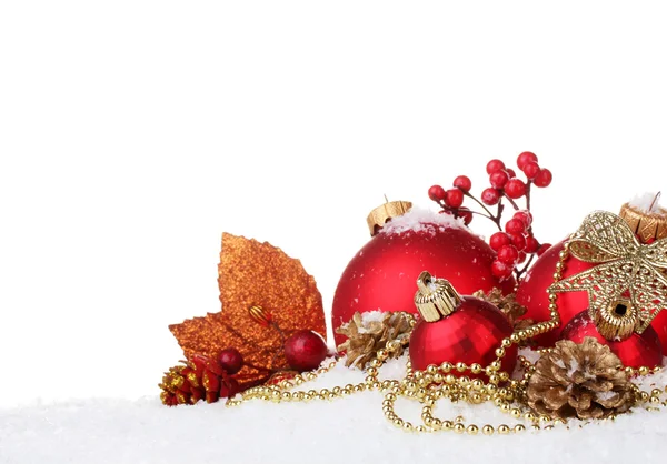Красиві червоні різдвяні кульки і шишки на снігу ізольовані на білому — стокове фото