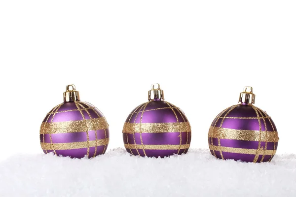 Красиві фіолетові різдвяні кульки в снігу ізольовані на білому — стокове фото
