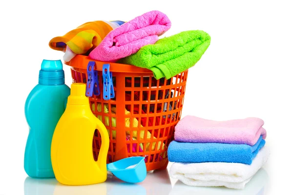 Vêtements avec détergent et poudre à laver dans un panier en plastique orange isolé — Photo