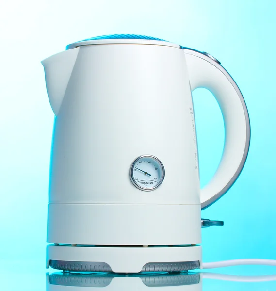 Белый электрический чайник на голубом — стоковое фото