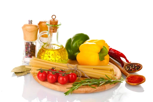 Espaguetis, frasco de aceite, especias y verduras sobre tabla de madera aislado en wh — Foto de Stock