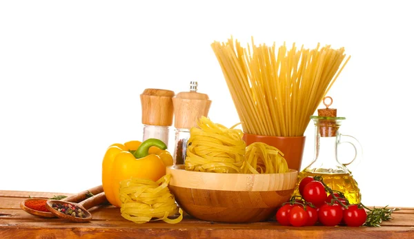 Spaghetti, makaron w misce, słoik oleju i warzywa na drewnianym stole isola — Zdjęcie stockowe