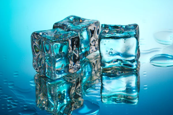 Eiswürfel auf blauem Hintergrund schmelzen — Stockfoto