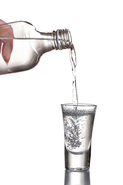 Vodka vertido en un vaso aislado en blanco — Foto de Stock