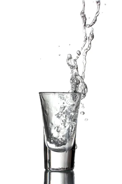 Βότκα, χύνεται ένα ποτήρι που απομονώνονται σε λευκό — Φωτογραφία Αρχείου