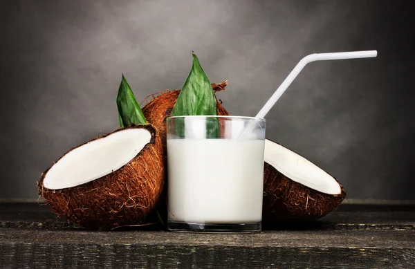 Kokosmilch und Kokosnuss auf grau — Stockfoto