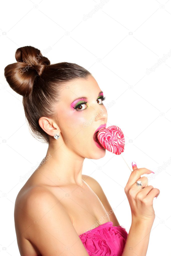 Young girl like a doll in pink dresses with heart-shaped candy isolated on