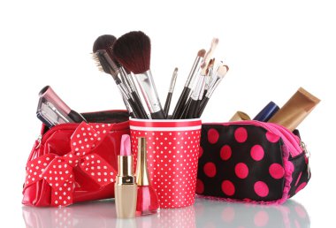 Red glass with brushes and makeup bag with cosmetics isolated on white clipart