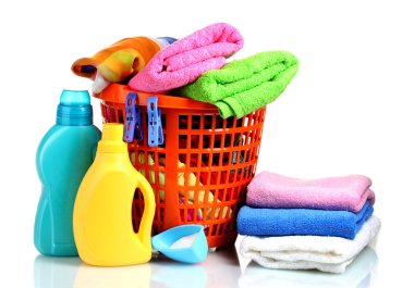 Clothes with detergent and washing powder in orange plastic basket isolated