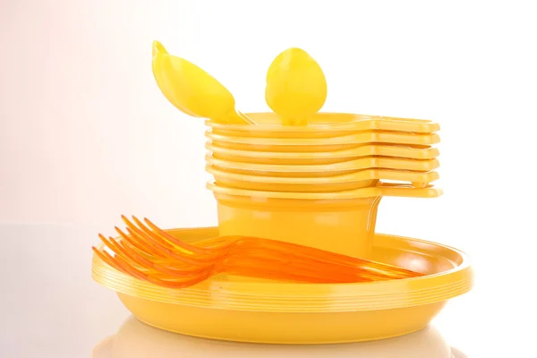 Ярко-желтая пластиковая посуда изолирована на белом — стоковое фото