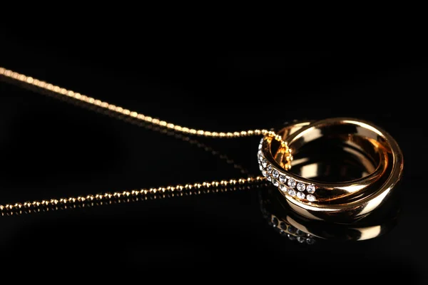 Pendentif en forme d'anneaux avec gemme sur noir — Photo