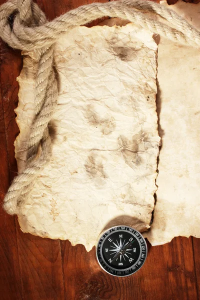 Gammelt papir, kompass og tau på et trebord – stockfoto