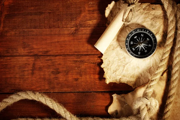 Régi könyv, az iránytű és a kötél egy fából készült asztal — Stock Fotó