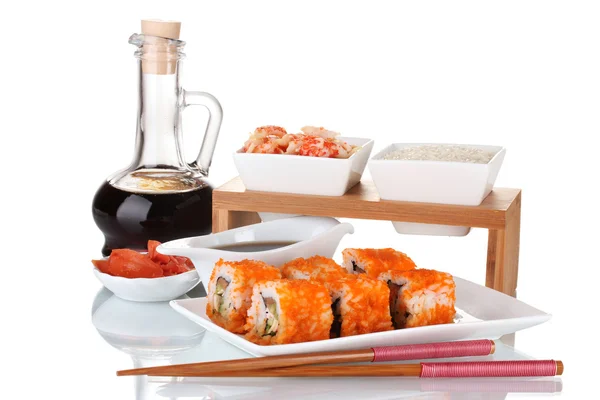 Delicious sushi on plate, chopsticks, soy sauce, fish and shrimps isolated — Stock Photo, Image