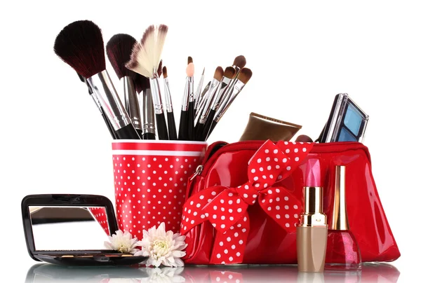 stock image Red glass with brushes and makeup bag with cosmetics isolated on white
