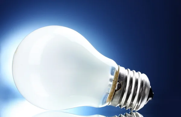 stock image Light bulb on blue background