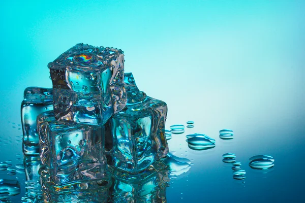 Derretimiento de cubitos de hielo sobre fondo azul —  Fotos de Stock