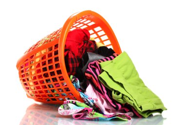 Clothes in orange plastic basket dropped isolated on white clipart