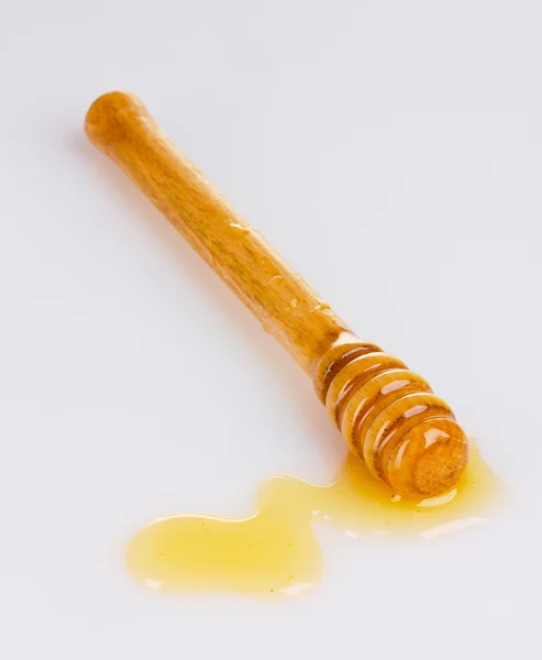 Μέλι ξύλινη κουτάλα με το μέλι που απομονώνονται σε λευκό — Φωτογραφία Αρχείου