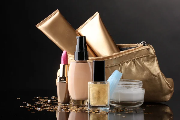 Güzel altın makyaj çantası ve siyah izole kozmetik — Stok fotoğraf