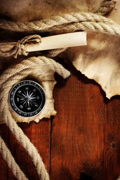 Papel viejo, brújula y cuerda sobre una mesa de madera — Foto de Stock