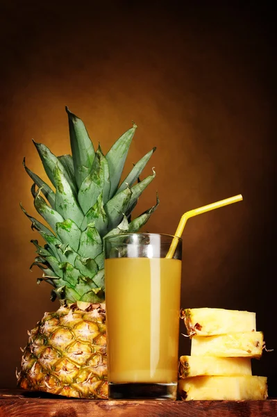 Ananassaft und Ananas auf braun — Stockfoto