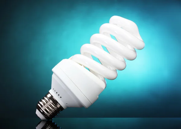 Lampe à économie d'énergie sur fond bleu — Photo