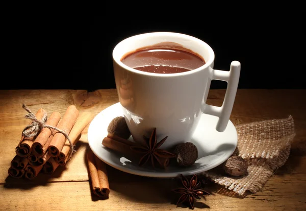 Чашка гарячого шоколаду, паличок кориці, горіхів та шоколаду на дерев'яному столі — стокове фото