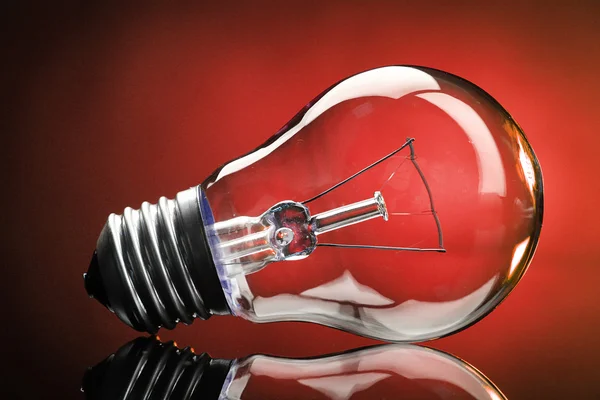 Light bulb on red background — Stock Photo, Image