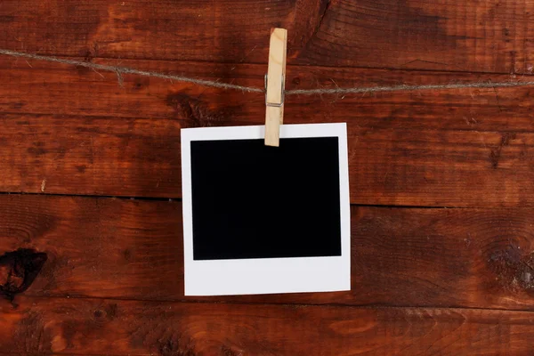 Fotopapier opknoping op de waslijn op houten achtergrond — Stockfoto