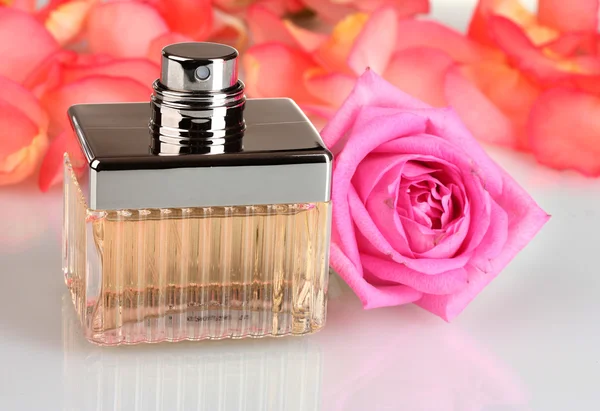 Parfüm in einer schönen Flasche, Blütenblätter und rosa Rose isoliert auf weiß — Stockfoto