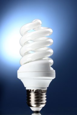 Energy saving lamp on blue background clipart