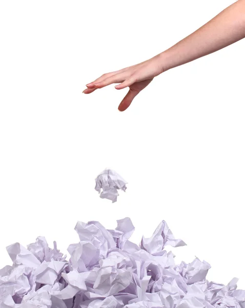 Стопка мятых бумажных шариков и рука, изолированная на белом — стоковое фото