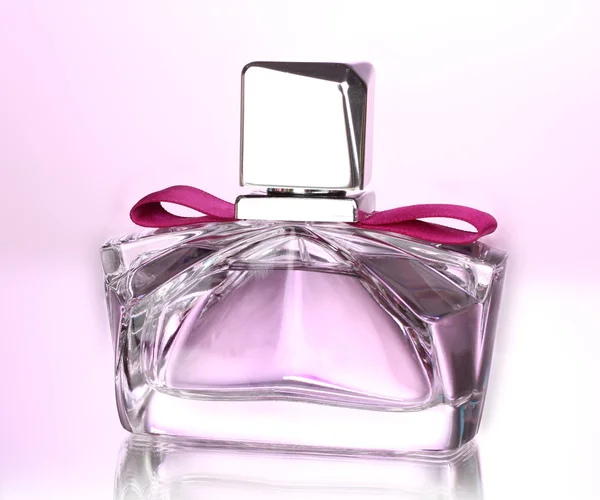 Жіночі парфуми в красивій пляшці на рожевому фоні — стокове фото