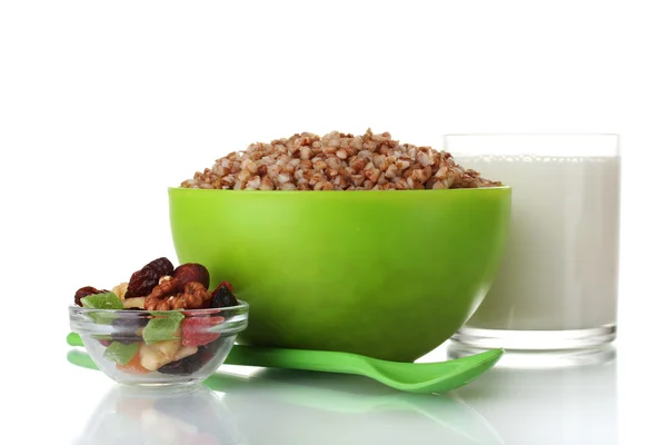 Boiled buckwheat in a green bowl a glass of milk isolated on white — Stock Photo, Image