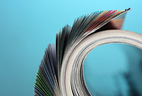 Rolled up magazines on blue background — Stock Photo, Image