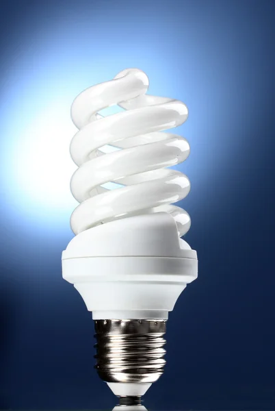 Lámpara de ahorro de energía sobre fondo azul — Foto de Stock