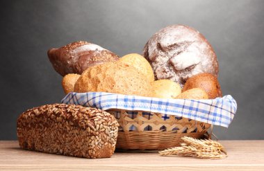 lezzetli ekmek sepeti ve gri arka plan üzerinde ahşap masa kulaklara