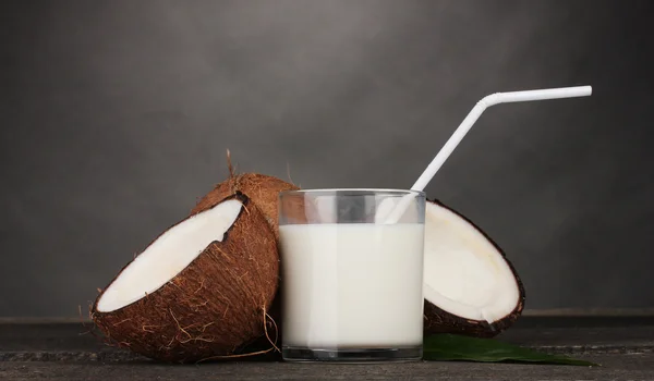Kokosmelk en kokosnoot op grijs — Stockfoto