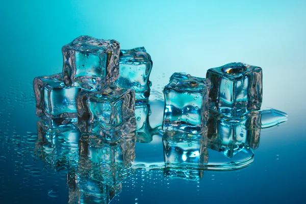 Scioglimento cubetti di ghiaccio su sfondo blu — Foto Stock