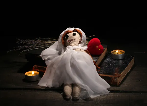 Voodoo-pop meisje-bruid op een houten tafel in het kaarslicht — Stockfoto