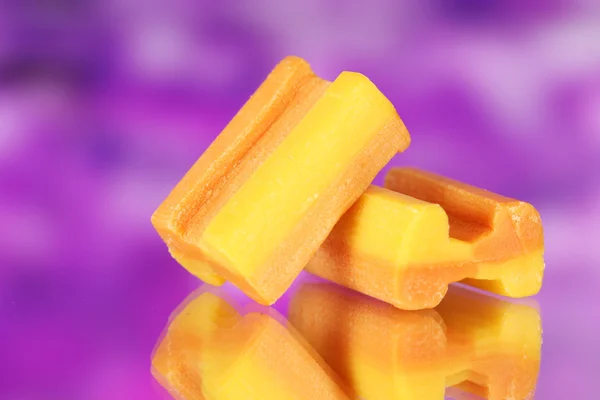 Gustosa gomma da masticare su sfondo viola — Foto Stock