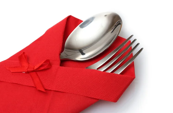 Πιρούνι και κουτάλι σε ένα κόκκινο πανί με ένα τόξο που απομονώνονται σε λευκό — Φωτογραφία Αρχείου